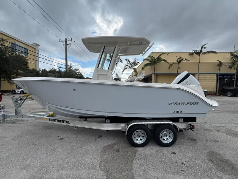 The Image of 2025 Sailfish 232 CC boat on trailer, parked outdoors under cloudy sky. - 0