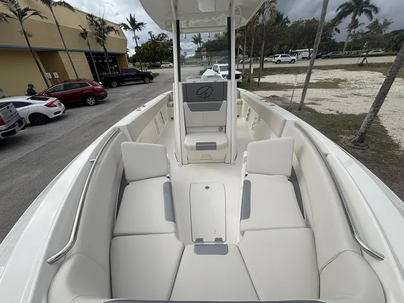 Slide: The Image of 2025 Sailfish 232 CC boat with spacious seating and sleek design in a parking lot. - 17