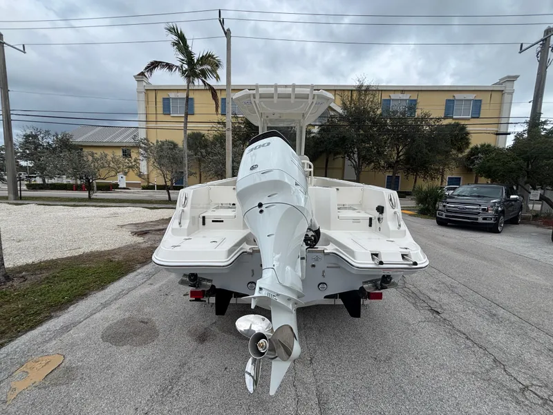 Slide: The Image of 2025 Sailfish 232 CC boat with outboard motor, parked on a street. - 2