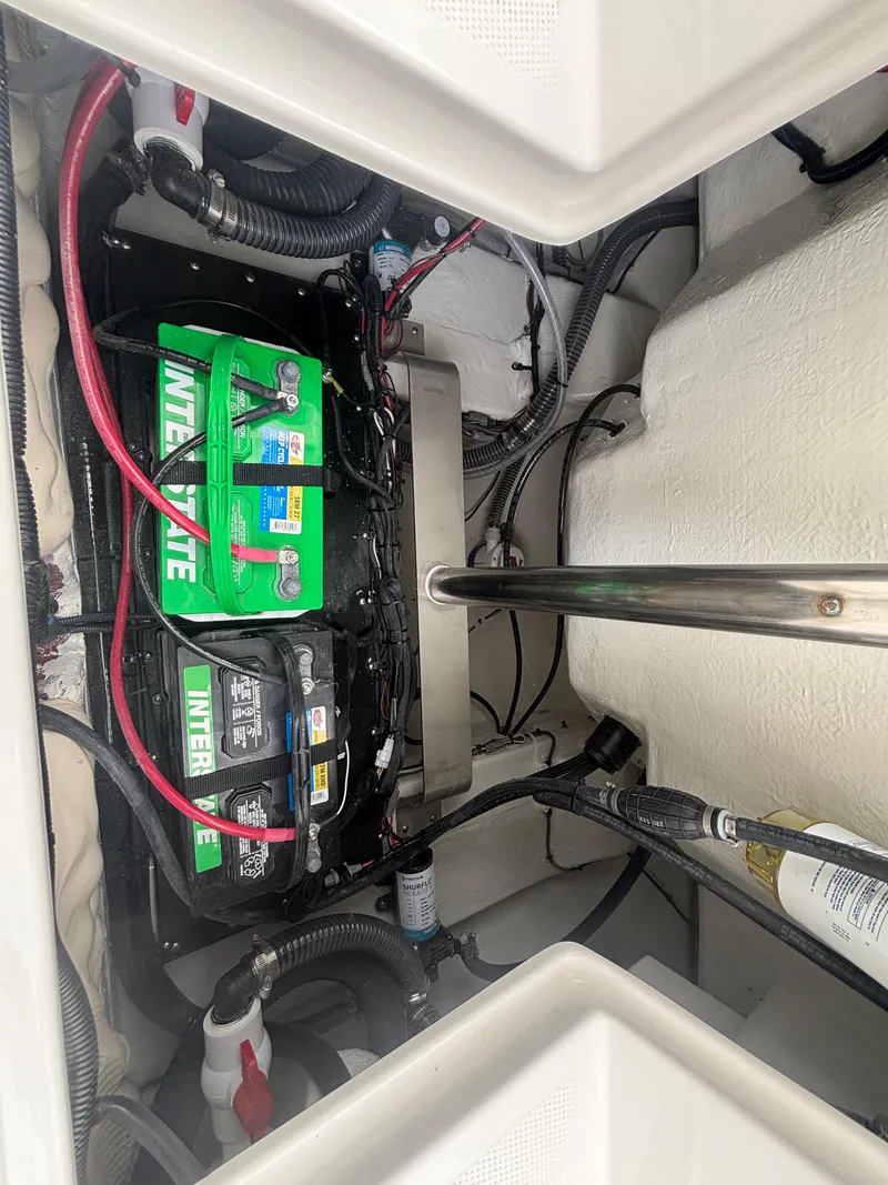 Slide: The Image of 2025 Sailfish 232 CC boat battery compartment with Interstate batteries and wiring. - 22