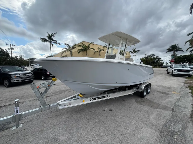 Slide: The Image of 2025 Sailfish 232 CC boat on trailer, parked outdoors under cloudy sky. - 5