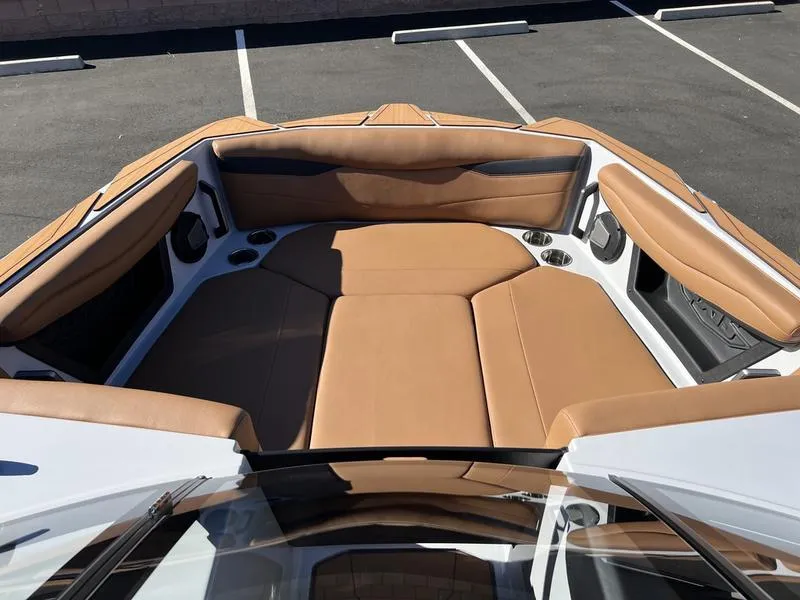 Slide: The Image of 2025 Axis A245 boat interior with tan leather seating and cup holders. - 14