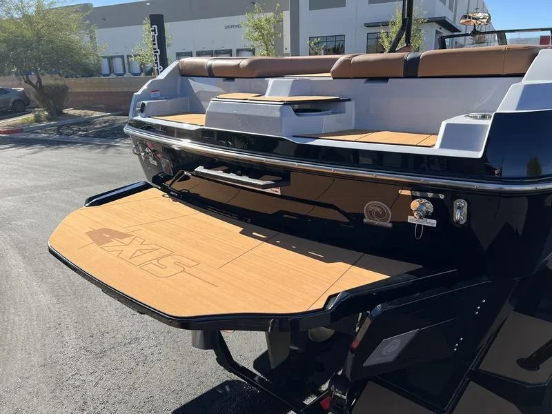 Slide: The Image of 2025 Axis A245 boat with teak swim platform in a sunny outdoor setting. - 5