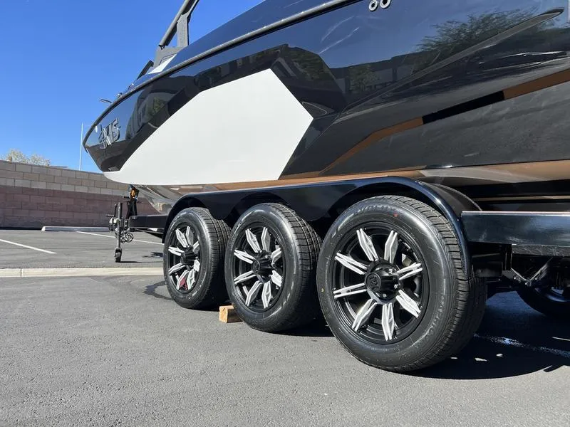 Slide: The Image of 2025 Axis A245 boat on trailer with triple-axle wheels in parking lot. - 6