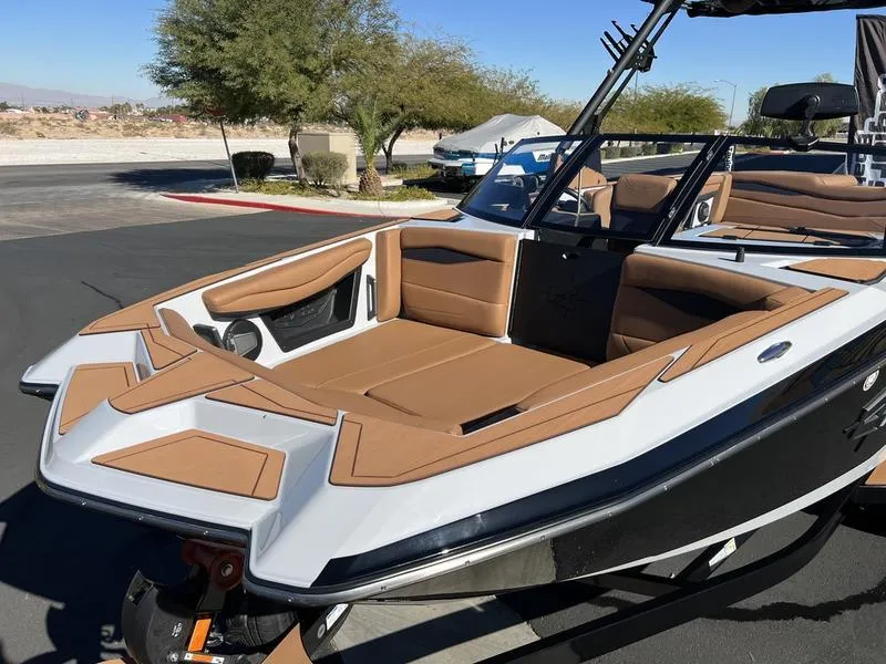Slide: The Image of 2025 Axis A245 boat with tan interior, parked outdoors on a sunny day. - 7