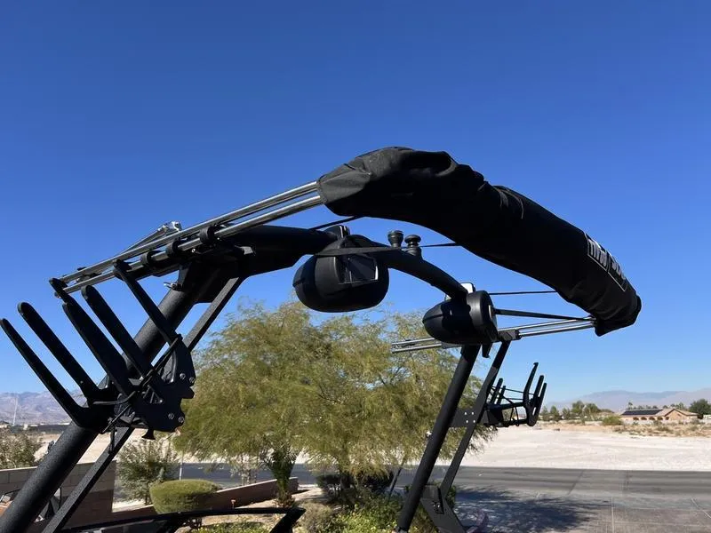 Slide: The Image of 2025 Axis A245 boat tower with wakeboard racks under clear blue sky. - 8