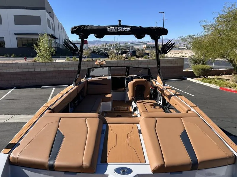 Slide: The Image of 2025 Axis A245 boat with tan interior, parked outdoors under clear blue sky. - 9