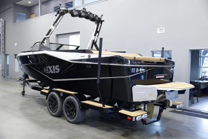 Slide: The Image of 2025 Axis T235 boat on trailer in showroom, black exterior, modern design. - 4