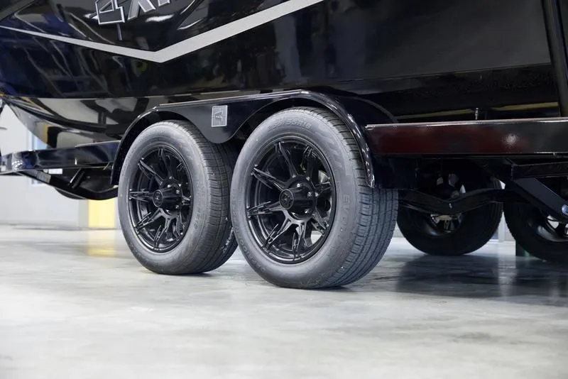 Slide: The Image of 2025 Axis T235 trailer with black wheels on a polished floor. - 6