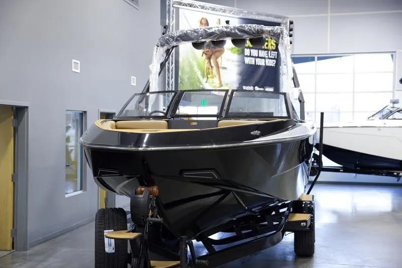 Slide: The Image of 2025 Axis T235 boat displayed indoors on a trailer. - 8