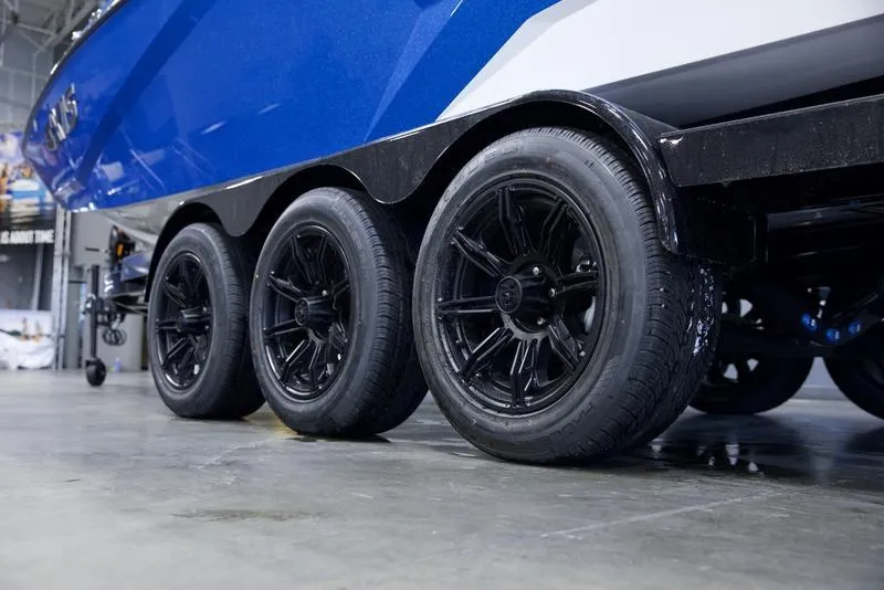 Slide: The Image of Axis A245 2025 boat trailer with triple black wheels in a showroom. - 6
