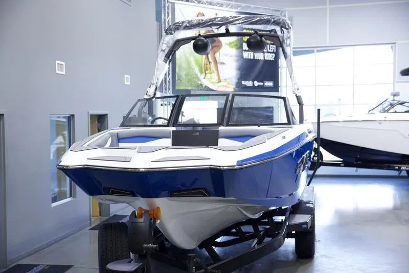 Slide: The Image of 2025 Axis A245 boat in showroom, blue and white design on trailer. - 8