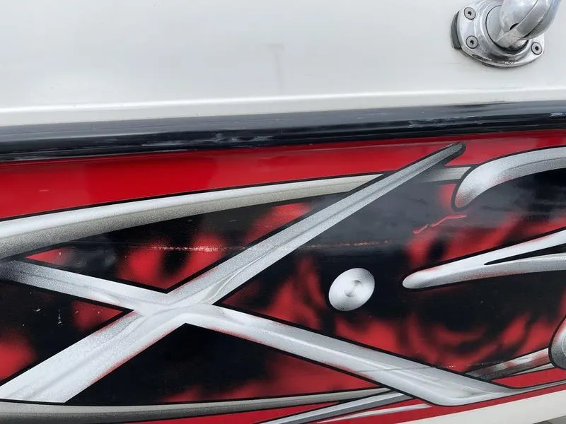 Slide: The Image of 2001 MasterCraft X30 boat with vibrant red and black abstract design. - 26