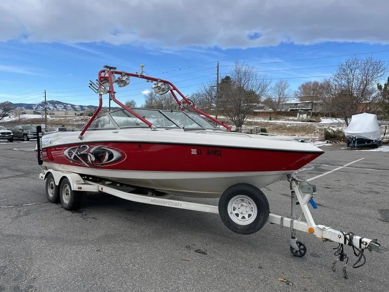 Slide: The Image of 2001 MasterCraft X30 boat on trailer, red and white design, parked outdoors. - 5