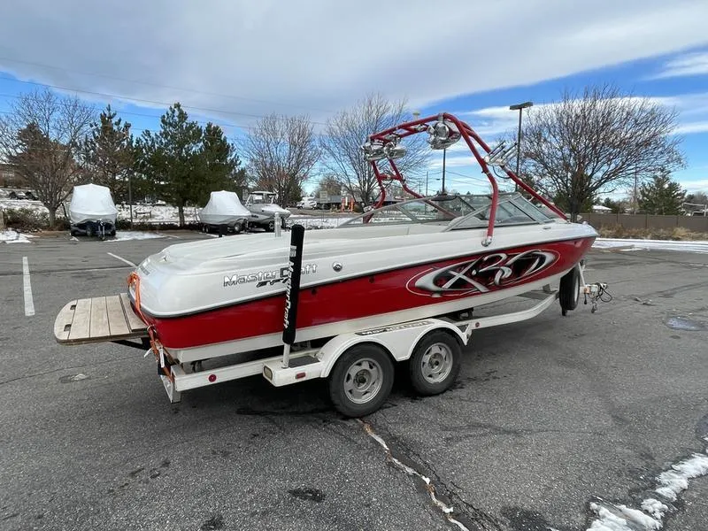 Slide: The Image of 2001 MasterCraft X30 boat on trailer in parking lot, red and white design. - 7