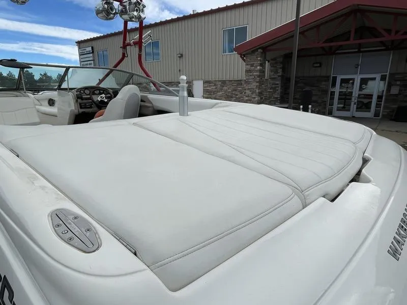 Slide: The Image of 2001 MasterCraft X30 boat with white upholstery, parked near a building. - 8