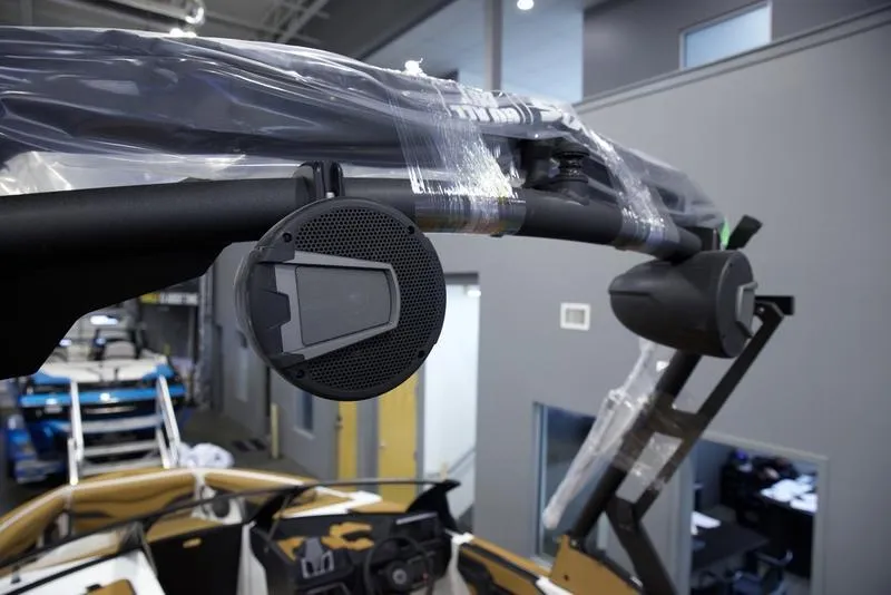 Slide: The Image of 2025 Axis T235 boat with mounted speakers in a showroom. - 10