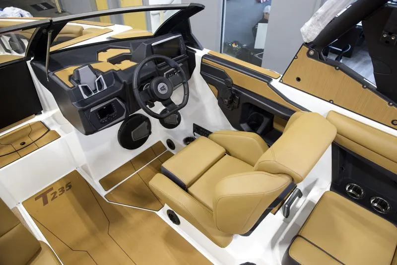 Slide: The Image of 2025 Axis T235 boat interior with tan leather seats and modern dashboard. - 11