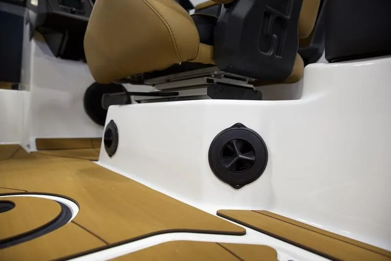 Slide: The Image of 2025 Axis T235 boat interior with tan seats and black speakers. - 14