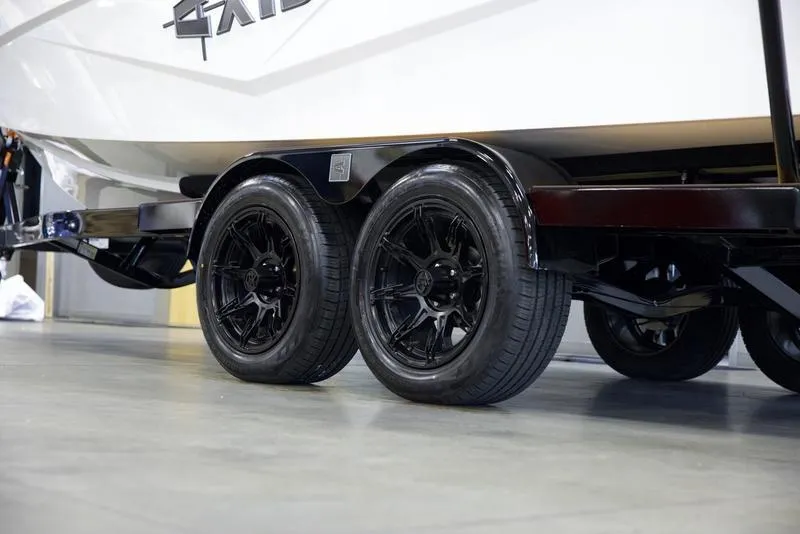 Slide: The Image of 2025 Axis T235 boat trailer with black wheels in a showroom. - 6
