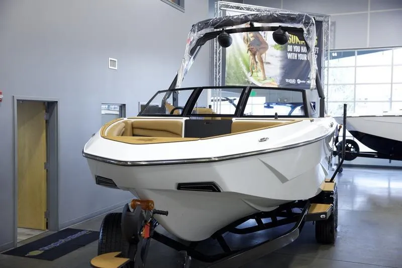 Slide: The Image of 2025 Axis T235 boat on display in showroom, sleek design, white exterior. - 8