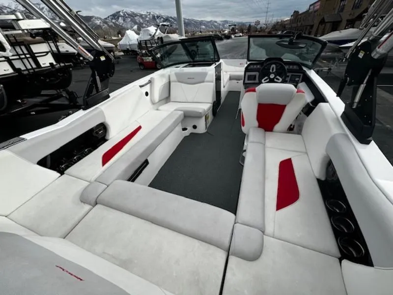 Slide: The Image of 2021 MasterCraft NXT22 boat interior with white and red seating, dashboard, and open layout. - 11