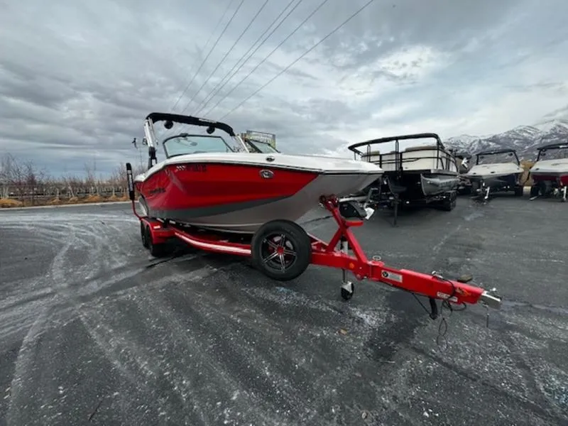Slide: The Image of 2021 MasterCraft NXT22 boat on a red trailer in a parking lot. - 5
