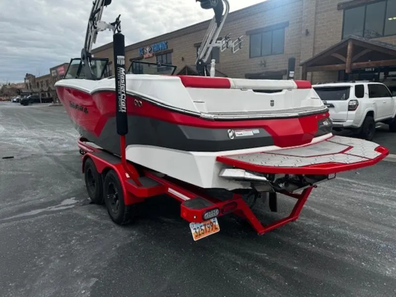 Slide: The Image of 2021 MasterCraft NXT22 boat on trailer, red and white, parked in a lot. - 7