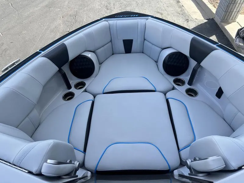 Slide: The Image of 2023 Malibu 23 LSV boat interior with plush seating and cup holders. - 17