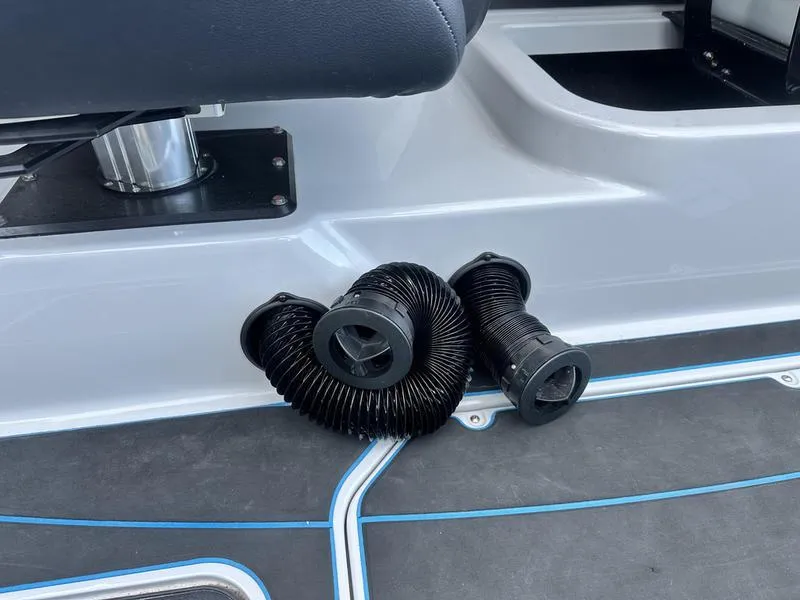 Slide: The Image of 2023 Malibu 23 LSV boat interior with coiled black hoses on the floor. - 20