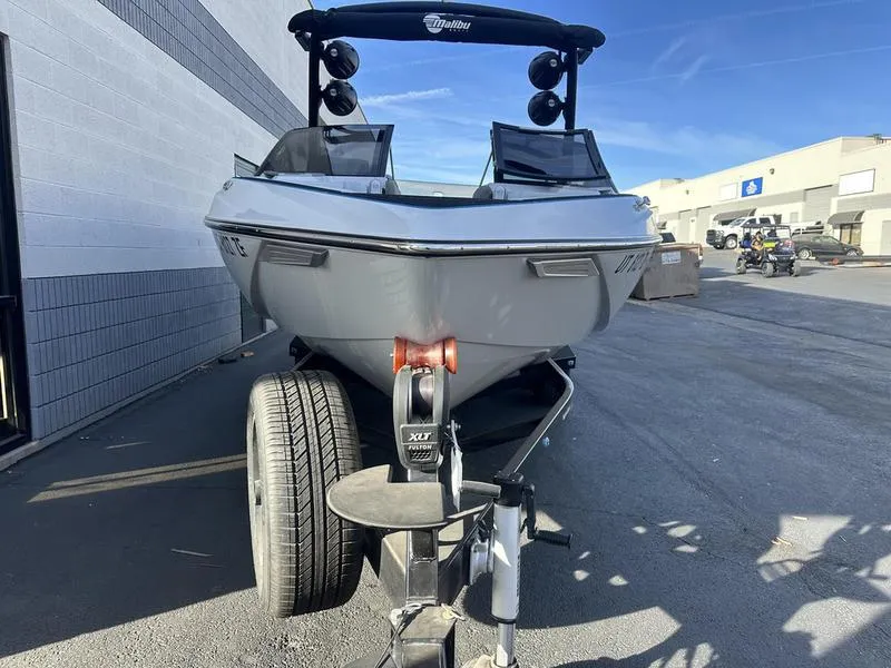 Slide: The Image of 2023 Malibu 23 LSV boat on trailer, parked outdoors. - 4