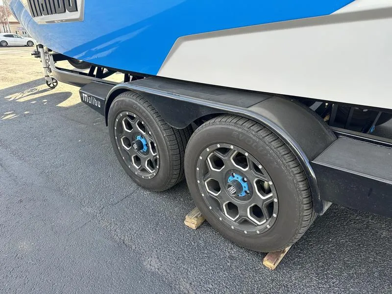 Slide: The Image of 2023 Malibu 23 LSV boat trailer with dual wheels on pavement. - 8