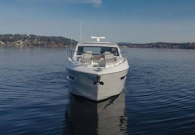 Slide: The Image of 2025 Cruisers Yachts 46 Cantius on serene lake, front view. - 2