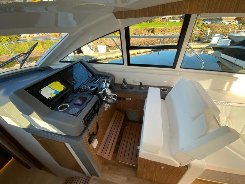 Slide: The Image of 2025 Cruisers Yachts 46 Cantius helm with modern controls and panoramic windows. - 29