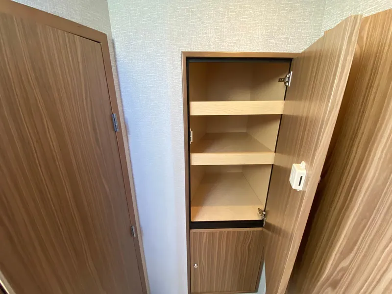 Slide: The Image of 2025 Cruisers Yachts 46 Cantius interior cabinet with open wooden shelves. - 40