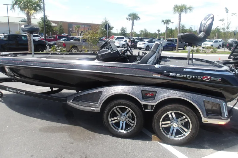 The Image of 2025 Ranger Z520R Cup-Equipped boat in parking lot, showcasing sleek design and dual-axle trailer. - 1