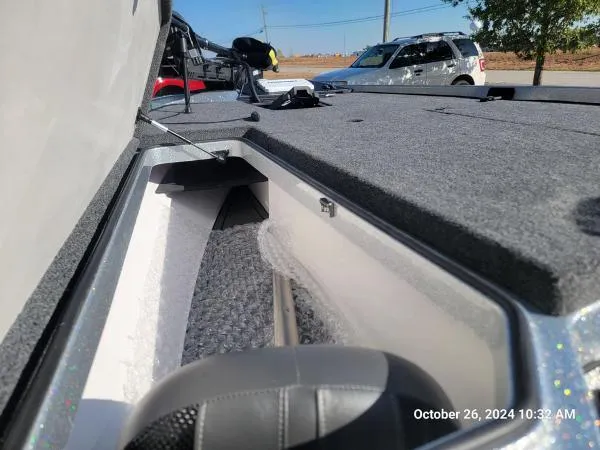 Slide: The Image of 2025 Ranger Z519R Cup-Equipped boat storage compartment, open lid, outdoor setting. - 8