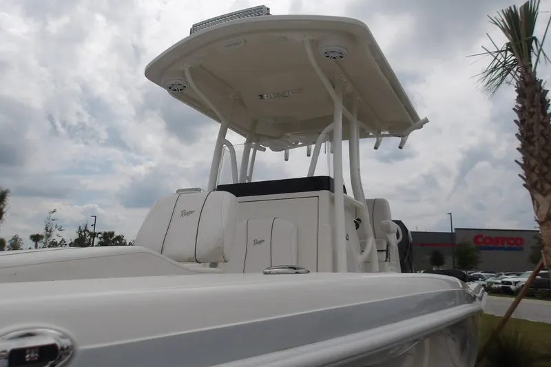 Slide: The Image of 2025 Ranger 2600 Bay boat with T-top, parked near a Costco under cloudy skies. - 15