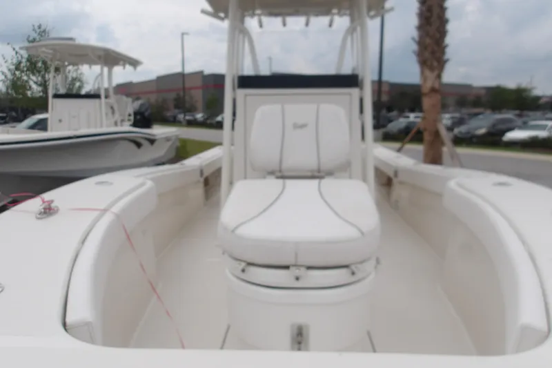 Slide: The Image of 2025 Ranger 2600 Bay boat with white seating, docked outdoors. - 16