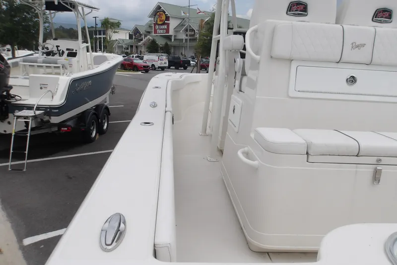 Slide: The Image of 2025 Ranger 2600 Bay boat in parking lot, showcasing sleek design and seating. - 17