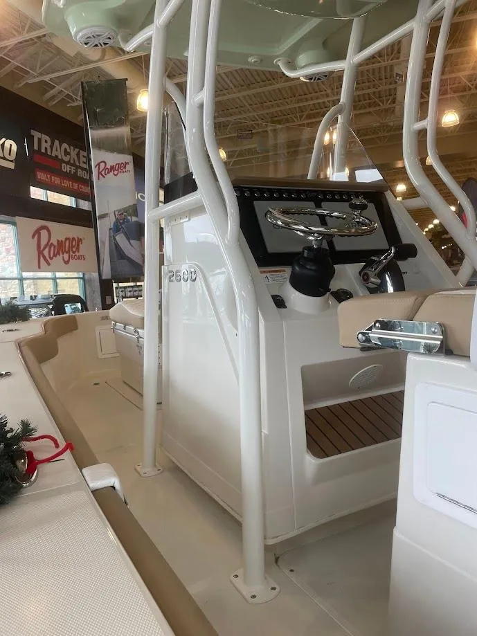 Slide: The Image of 2025 Ranger 2600 Bay boat interior at showroom, featuring control panel and seating. - 2