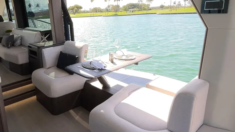 Slide: The Image of Luxurious interior of 2025 Galeon 560 Fly yacht with elegant dining setup by the water. - 9