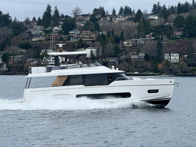 Slide: The Image of 2025 Azimut Magellano 60 yacht cruising on a scenic lake. - 10