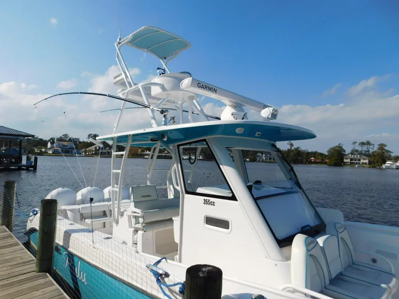 Slide: The Image of 2016 Everglades 355 Center Console boat docked by a serene lake. - 10