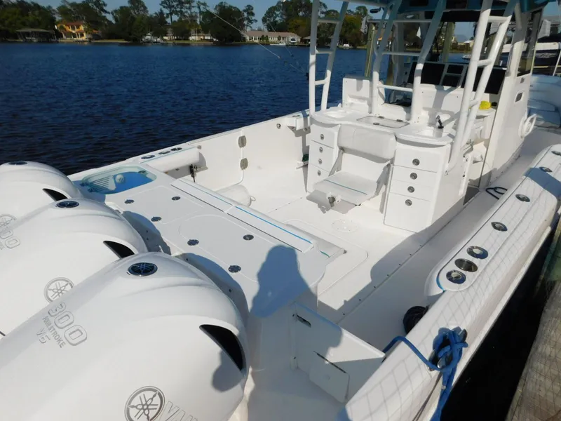Slide: The Image of 2016 Everglades 355 Center Console boat with triple outboard engines on a calm lake. - 13