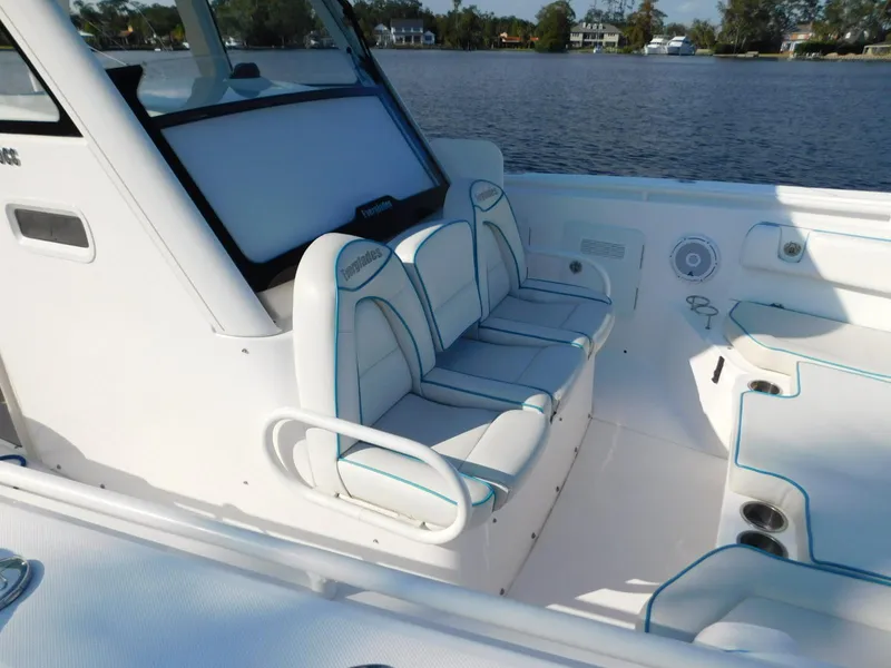 Slide: The Image of 2016 Everglades 355 Center Console boat interior with white seating and blue accents. - 16