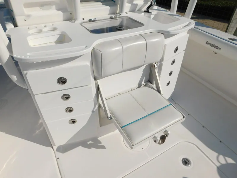 Slide: The Image of 2016 Everglades 355 Center Console boat interior with white seating and storage compartments. - 19