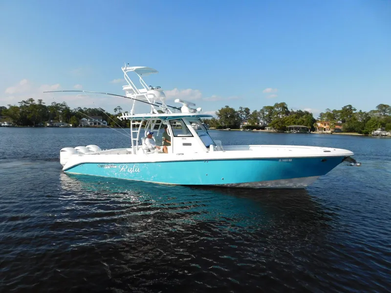 Slide: The Image of 2016 Everglades 355 Center Console boat on calm water, blue and white design. - 2