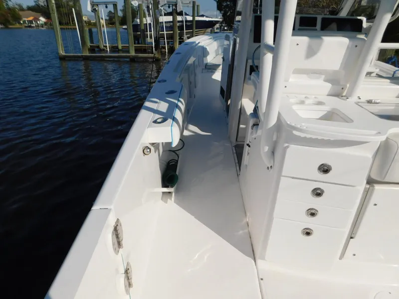 Slide: The Image of 2016 Everglades 355 Center Console boat docked by the water, showcasing deck and storage features. - 24