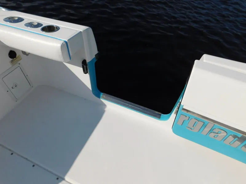 Slide: The Image of 2016 Everglades 355 Center Console boat, featuring sleek white and blue design, on water. - 25